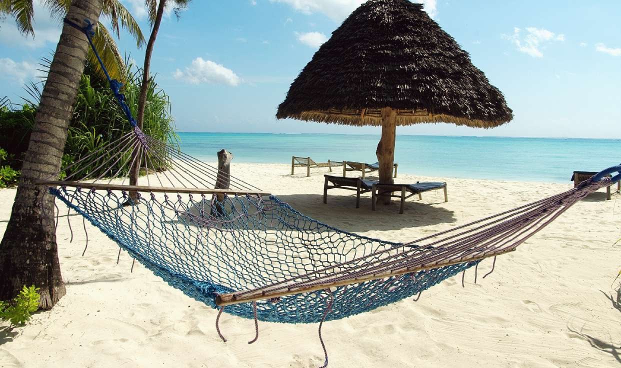 Un hamac sous les palmiers, sur une plage de sable blanc à Zanzibar